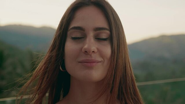 Close-up portrait of young woman with long hair open eyes looking feel happy the morning sun is shining and the wind blow