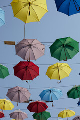 Fototapeta na wymiar Street decoration of colorful umbrellas. Colorful umbrellas in the sky.