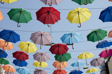 Fototapeta na wymiar Street decoration of colorful umbrellas. Colorful umbrellas in the sky.
