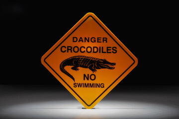 Danger crocodiles no swimming sign in the dramatic light