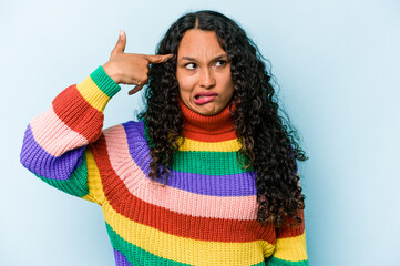 Young hispanic woman isolated on blue background showing a disappointment gesture with forefinger.