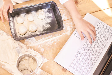 Young girl cooking at kitchen. Curly pretty child portrait. Chef student. Attractive brunette. Children emotion. People baking in cook apron. Close recipe menu