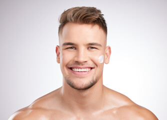 Obraz premium It works like a dream. Studio shot of a young man applying moisturizer to his face against a grey background.