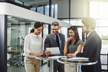 Getting positive feedback. Shot of a group of colleagues discussing business in the office.