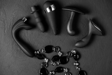 Erotic pleasure toys on a black background. Sex gadgets and masturbation devices. Pink dildo...