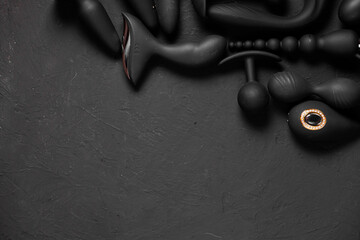 Erotic pleasure toys on a black background. Sex gadgets and masturbation devices. Pink dildo...