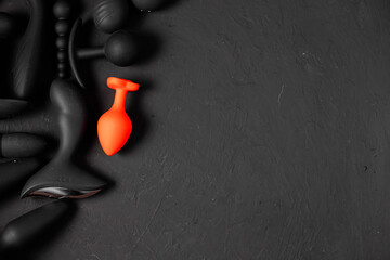 Erotic pleasure toys on a black background. Sex gadgets and masturbation devices. Pink dildo...