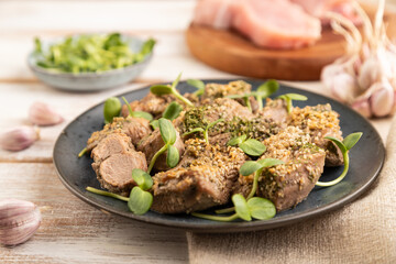 Stewed turkey fillet with sprouts of sunflower on white wooden background. Side view, close up.