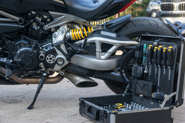 A case of technical instruments standing next to the motorcycle