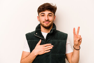 Young hispanic man isolated on white background taking an oath, putting hand on chest.