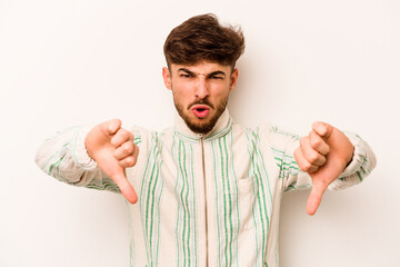 Young hispanic man isolated on white background showing thumb down and expressing dislike.
