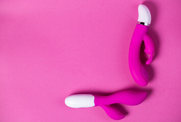 Sex toys. Purple and pink vibrators isolated on a pink background