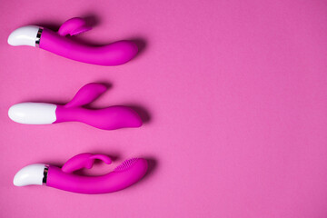 Sex toys. Purple and pink vibrators isolated on a pink background