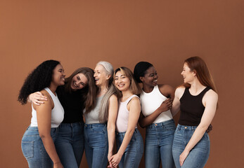 Six laughing women of different body types and ethnicities in studio. Group portrait of smiling...