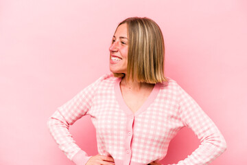 Young caucasian woman isolated on pink background laughs happily and has fun keeping hands on...