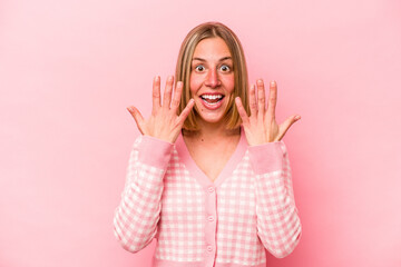 Young caucasian woman isolated on pink background showing number ten with hands.