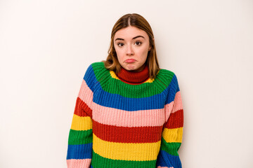 Young caucasian woman isolated on white background shrugs shoulders and open eyes confused.