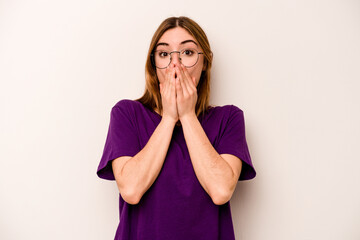 Young caucasian woman isolated on white background shocked covering mouth with hands.