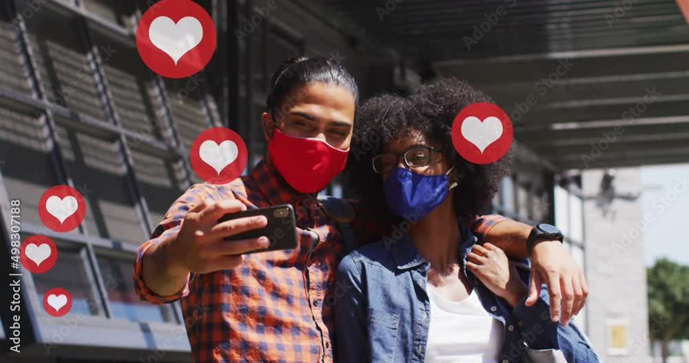 Canvas Prints Video of falling icons over diverse man and woman wearing face masks and using technology