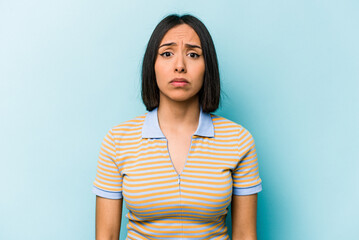 Fototapeta premium Young hispanic woman isolated on blue background sad, serious face, feeling miserable and displeased.