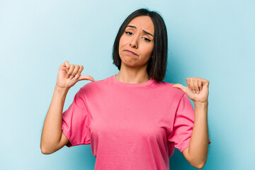 Young hispanic woman isolated on blue background feels proud and self confident, example to follow.