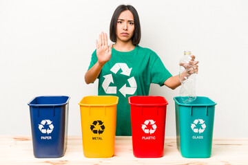 Young hispanic woman recycling plastic isolated on white background