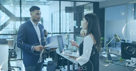 6g and 5g texts against diverse male and female office colleagues discussing together at office - Powered by Adobe