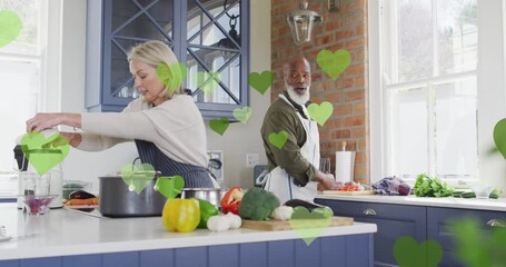Animation of heart icons over diverse couple cooking together - Powered by Adobe