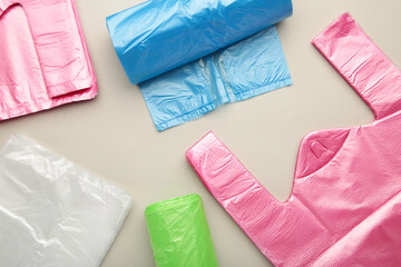 A lot of colored plastic bags rolls on a grey background.