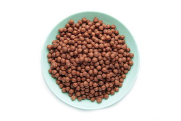 Fototapeta premium Chocolate cereal corn balls in a blue bowl isolated on a white background.