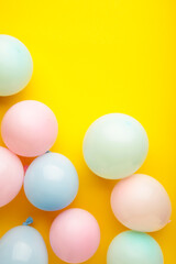 Birthday background with colorful balloons on yellow background, top view