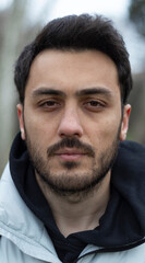 Obraz premium Portrait of man. No expression on his face. Outdoor background. Close up photo.