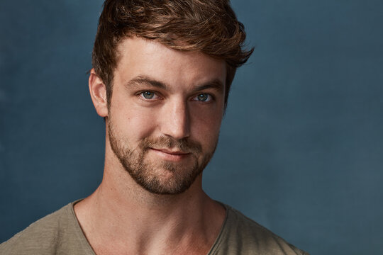 Keeping It Simply Cool. Studio Portrait Of A Handsome Young Man Posing Against A Dark Background.