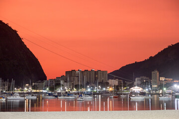 sky with the color red, under the influence of the ashes of the volcano of tonga in the cove of Botafogo in Rio de Janeiro, Brazil.