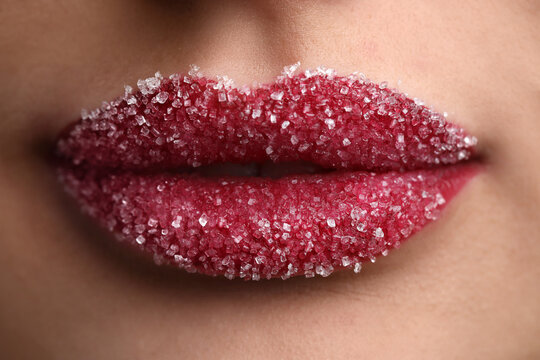 Young woman with beautiful lips covered in sugar, closeup