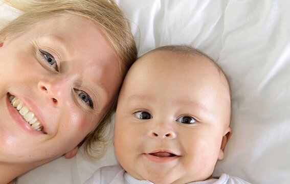 baby with his mother been cared for after having a good night sleep in bed at home stock photo 