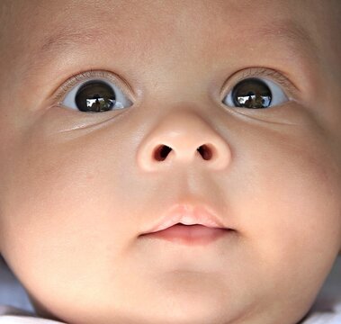 baby looking with big eyes just after having a good sleep in bed stock photo
