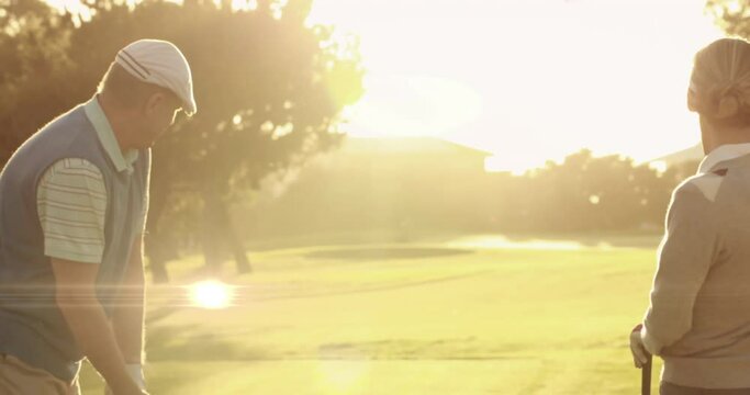 Animation of light trails ver senior caucasian couple playing golf on golf course