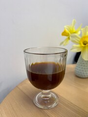 coffee in a glass and yellow flowers
