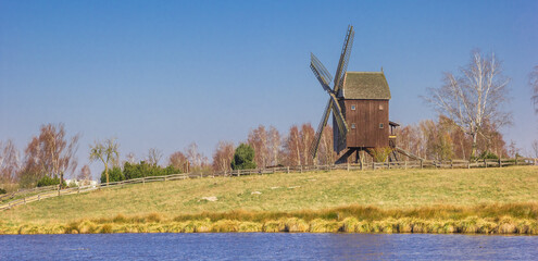 Panorama of a historic wooden windmill at the lake in Gifhorn, Germany