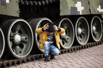 Tank and howitzer stand on the street in Ukraine. In the Kiev park there is a gun and a green tank.