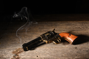 the aftermath of a gunfight with gunslinger's pistol laying on saloon floor with smoke streaming...