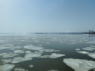 Ice drift on the river in spring. Embankment in the city of Saratov. Sunny day in April