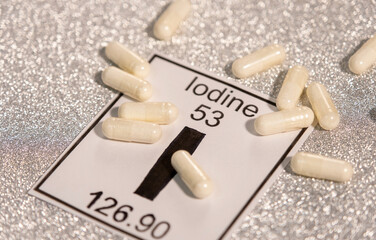 Multiple anti-radiation pills based on iodine on a white background near the chemical element of...