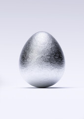 Chocolate easter egg with shiny silver Aluminium foil on white background. Close-up.