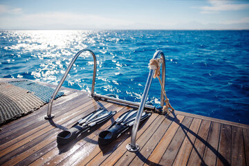 Diving with scuba gear and flippers in sea, snorkeling tour on boat yacht. Bright photo with sun...