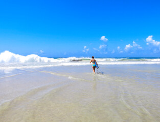 Girl Running Towards Waves