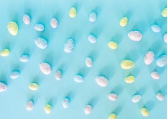 Easter concept. Multicolored pastel eggs on a blue background. Top view.