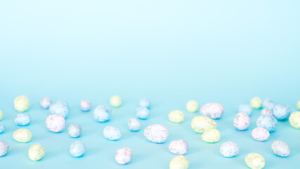 Easter concept. Multicolored pastel eggs on a blue background.  Long banner format