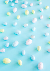 Easter concept. Multicolored pastel eggs on a blue background. Top view.